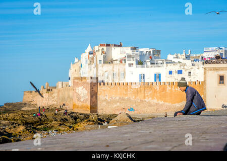 ESSAOUIRA, Marokko - Dezember 13: Guy sitzen auf der alten Stadtmauer in Essaouira. Dezember 2016 Stockfoto