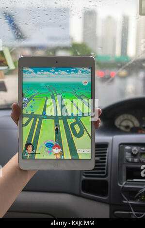 Bangkok, Thailand - 7 August 2016: Hand Apple Ipad Mini 2 Tablette die Pokemon Gehen, das am Bildschirm im Auto auf dem Weg Foto b Stockfoto