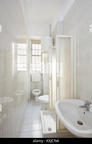 Altes Badezimmer Einrichtung mit gefliestem Fußboden und Wände Stockfoto