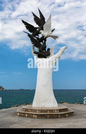KUSADASI, Türkei - 20. AUGUST 2017: die Hand des Friedens Skulptur mit Tauben auf der Uferpromenade in Kusadasi, Türkei Stockfoto