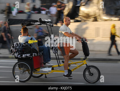 London, Großbritannien, 11. September 2007: ein Fahrgast Fahrten in einem Dreirad Rikscha durch den Trafalgar Square Stockfoto