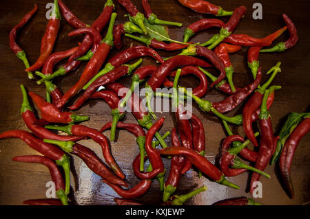 Einen großen Haufen von reifes rote Chilis oder Chili peppers auf alten Holztisch Hintergrund. Stockfoto