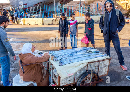 ESSAOUIRA, Marokko - Dezember 13: Frau verkaufen frischen Fisch auf dem Stand in Essaouira Fischereihafen. Dezember 2016 Stockfoto