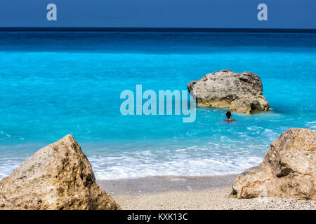 Menschen schwimmen im Meer am Strand Megali Petra Beach in Lefkada Insel, Griechenland Stockfoto