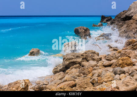 Meer Wellen auf die Felsen am Strand Megali Petra Beach in Lefkada Insel, Griechenland Stockfoto