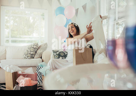 Lächelnden jungen schwangeren Frau Geschenke, die von Ihren Freunden. Weibliche Öffnung präsentiert, die auf Babyduschepartei. Stockfoto