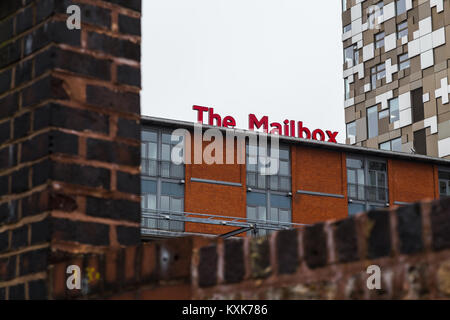 Eine leuchtend rote Zeichen der neuen Mailbox Shopping Mall im Herzen von Birmingham über eine rustikale alte Mauer am Ufer des Kanals gesehen, und der neue Cube Stockfoto