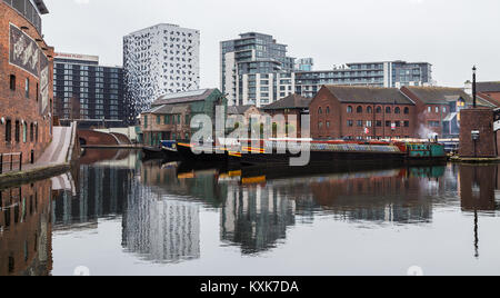 Moderne Gebäude und Hausbooten spiegeln sich im Wasser des Birmingham Canal alte Linie, die in die Innenstadt führt. Stockfoto