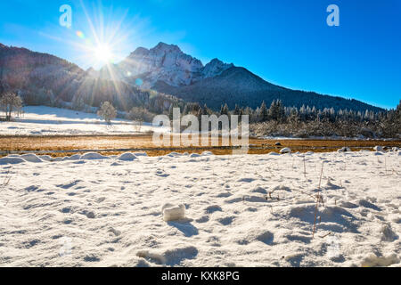 Bereich der Schnee am Zelenci und die Sonne hinter den Bergen Stockfoto