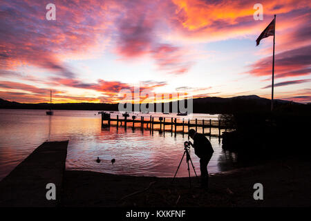 Ein Fotograf fängt den Sonnenuntergang am Waterhead, in Ambleside über Lake Windermere, Lake District National Park, Cumbria, Großbritannien, am 1. Dezember 20 genommen Stockfoto