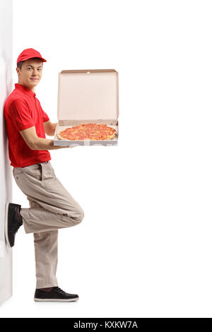 In voller Länge Porträt einer Jugend Pizza Delivery boy gegen eine Wand gelehnt auf weißem Hintergrund Stockfoto