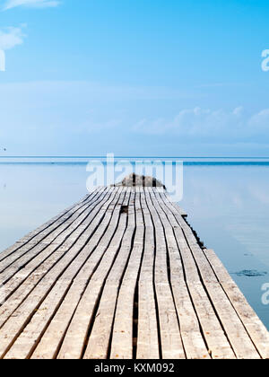 Djerba, Tunesien, Holzsteg mit alten Achsen konvergieren gegen Unendlich und Horizont im Meer Stockfoto