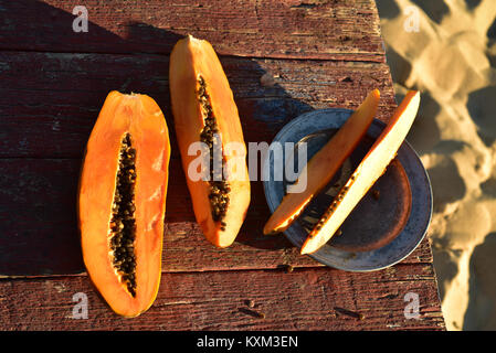 Frisch papaya auf rustikalen Holztisch sand Strand Küste Baja, Mexiko Stockfoto