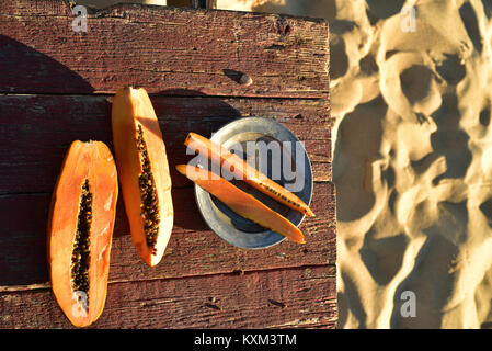 Frisch papaya auf rustikalen Holztisch sand Strand Küste Baja, Mexiko Stockfoto