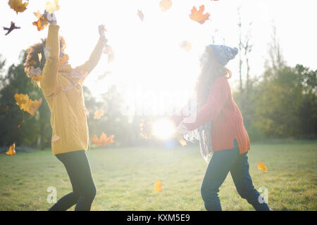 Freunde werfen Blätter im Herbst in der Luft Stockfoto