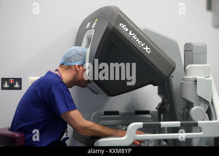 Der Herzog von Cambridge schaut durch ein Dual Console des Da Vinci Roboter während führen Chirurg Vin Paleri (Frame) führt eine Robotic assisted Deichsel hemiglossectomy Chirurgie auf Patienten Anne Weiß, 67, bei seinem Besuch im Royal Marsden NHS Foundation Trust in London. Stockfoto