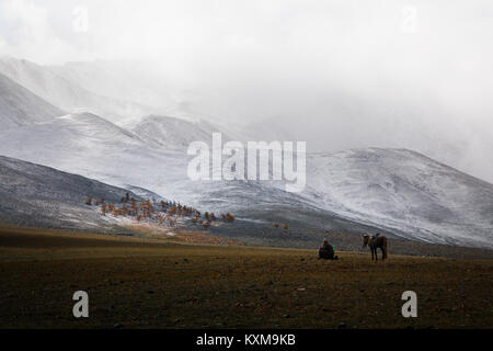 Ziege keeper Schäfer Pferd Reiter ruhenden mongolischen Winter Snowy Mountains Stockfoto