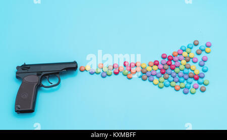 Pistole schießende Süßigkeiten, Applique Kunstwerk, Schuss aus einem Gewehr Aroma bunte Bonbons und Gummibärchen Stockfoto