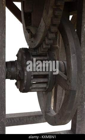 Alte hölzerne Zahnräder der Winde an der gut auf den weißen Hintergrund Stockfoto