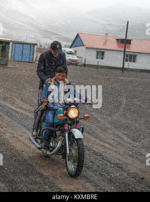 Land ländliche zwei junge Männer reiten Motorrad schnee winter kalt Mongolei Stadt Stockfoto