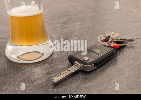 Glas Bier und Auto Taste auf Graue Tabelle Stockfoto