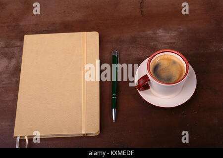 Notebook mit Stift und Kaffee Tasse auf hölzernen Hintergrund, Business Konzept Stockfoto