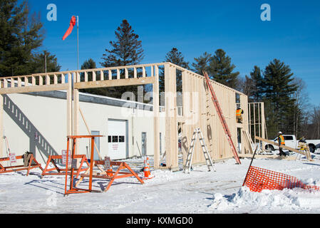 Tischler arbeiten an Framing eine Ergänzung zu einem Gebäude in Spekulant, New York, im Winter. Stockfoto