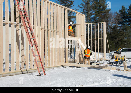 Tischler arbeiten an Framing eine Ergänzung zu einem Gebäude in Spekulant, New York, im Winter. Stockfoto