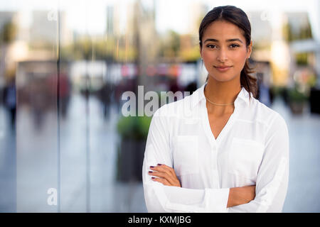Ernsthafte Karriere motiviert erfolgreiche weibliche Business Professional stehen stolz und selbstbewusst in der Nähe der Innenstadt auf die Gebäude Stockfoto