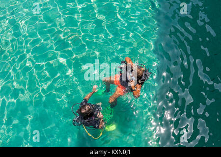 Eine Gruppe von Studenten Tauchen haben eine Lektion im flachen kristallklarem Wasser von einer tropischen Insel. Stockfoto