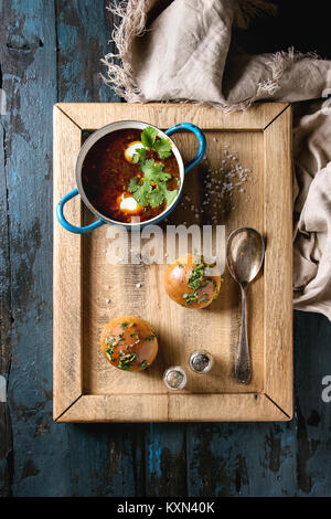 Pan der traditionellen Rote-Bete-Suppe Borschtsch mit saurer Sahne und frischem Koriander serviert mit Knoblauch Brötchen pampushki, auf Holz Fach mit textilen Leinen Stockfoto