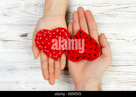 Mann ein weißes Herz zärtlich mit einer Frau. Valentinstag Konzept auf einer hölzernen Hintergrund, Ansicht von oben. Stockfoto