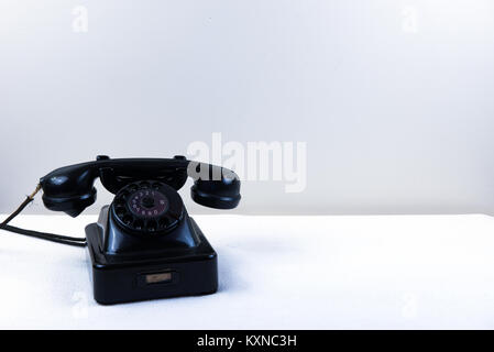 Vintage Piano Black Telefon mit klassischen Drehschalter auf weißem Hintergrund Stockfoto