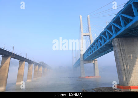 (180111) - chongqing, Jan. 11, 2018 (Xinhua) - Die Neue Baishatuo Yangtze Eisenbahnbrücke (R) ist mit dem vorherigen Baishatuo Yangtze Eisenbahnbrücke in Jiangjin im Südwesten Chinas Chongqing Gemeinde, Jan. 9, 2018 gesehen. Der Bau der neuen Double Decker steel truss Kabel bleiben Eisenbahnbrücke vor kurzem abgeschlossen wurde. Es hat 4 Tracks auf dem oberen Deck für Züge mit einer Geschwindigkeit von 200 Metern pro Stunde und 2 Titel auf dem unteren Deck für Güterzüge mit der Geschwindigkeit von 120 Kilometern pro Stunde. Die Gesamtlänge der Brücke ist 5,32 Kilometer, von denen Stockfoto