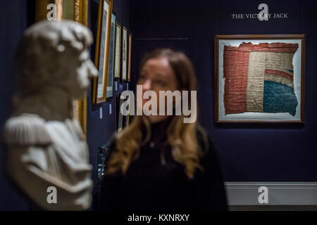 London, Großbritannien. 11. Januar, 2018. Ein großer Rest der HMS Victory Union Jack aus der Schlacht von Trafalgar est. £ 80.000, die im Hintergrund von anderen Verkauf Einzelteile einschließlich einer Büste von Nelson und einige seiner Tischgeschirr -100,000 - Sotheby's London" Der königliche und adelige Abstammung" Verkauf umfasst über 250 königliche und adelige Erbstücke, einschließlich einer Kopie der Britischen Kronjuwelen. Das Ensemble von Möbeln, Gemälden, die dekorativen Künste und wertvolle Objekte auctionedon vom 17. Januar 2018. Credit: Guy Bell/Alamy leben Nachrichten Stockfoto