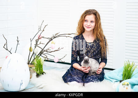 Zehn Jahre Mädchen sitzen mit Bunny Stockfoto