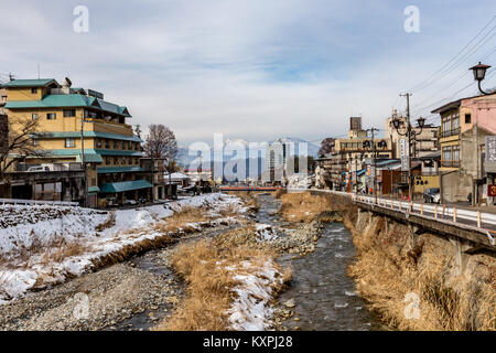 Das Dorf Yamanouchi mit dem Yokoyu Fluss, der durch das Zentrum. Stockfoto