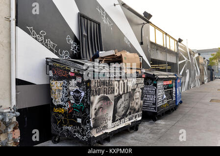 Künstlerische graffiti auf einer Gasse Wand- und Papierkorb Müllcontainer im Arts District, Downtown, Los Angeles, Kalifornien. Stockfoto