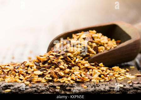 Holz- Schaufel mit getrockneten Chili und Knoblauch auf Tisch Stockfoto