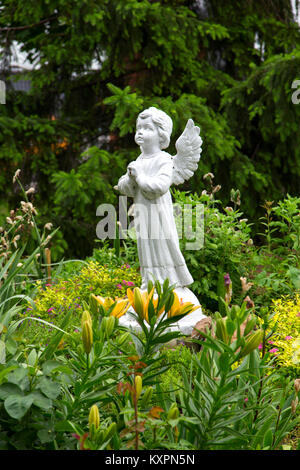 Engel Statue im Garten. Im Sommer, viel Kraut Stockfoto