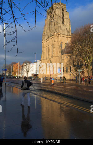 Die Heiligen Namen Kirche, die sich auf nasser Fahrbahn reflektierte, Oxford Road, Manchester, UK Stockfoto