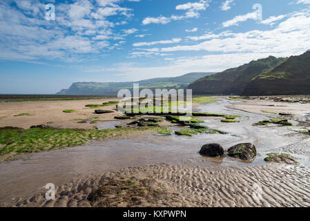 Schöner Strand und hohen Klippen an Robin Hood's Bay an der Küste von North Yorkshire, England. Blick Richtung Ravenscar. Stockfoto