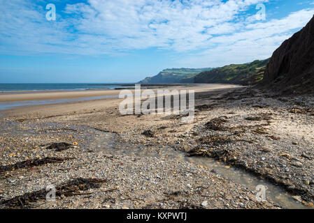 Schöner Strand und hohen Klippen an Robin Hood's Bay an der Küste von North Yorkshire, England. Blick Richtung Ravenscar. Stockfoto