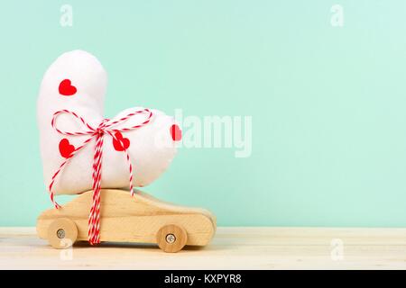 Holzspielzeug mit hausgemachten Herzen Geschenk gegen einen türkisen Hintergrund. Valentines Tag oder Liebe Konzept. Stockfoto
