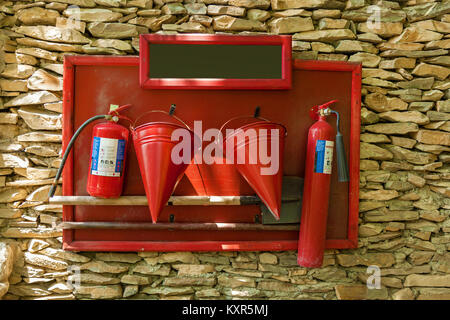 Ein Schutzschild mit einem Werkzeug für Feuerwehrleute: Eimer, Schaufel, Feuerlöscher, Schrott. Schutzschild mit einem Werkzeug für Feuerwehrleute. Reise nach Georgien Stockfoto