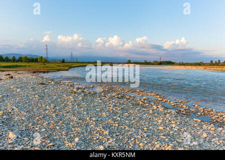 Runde weiße Steine liegen am Ufer eines Cold mountain river vor dem Hintergrund. mountain river mit weissen Steinen am Ufer.. Reise nach Georgien Stockfoto