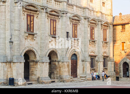 Die älteren Einheimischen Rest und Chat auf der Bank vor der majestätischen Renaissance Palast auf dem Hauptplatz (Piazza Grande) von Montepulciano - Toskana, I Stockfoto