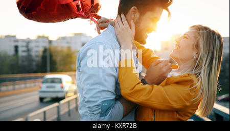 Paar in der Liebe kuscheln, während Schöne städtische Sonnenuntergang zu genießen Stockfoto