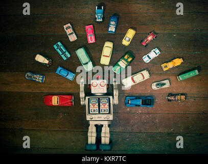 Vintage Roboter Spielzeug umgeben von viel retro Metall Spielzeugautos Stockfoto