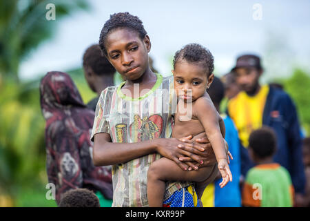 Unbekanntes KLEINES DORF, IRIAN JAYA, Neuguinea, Indonesien - 22. MAI 2016: Portrait von nicht identifizierten Papua kleines Mädchen Holding baby boy auf den Händen. Ein Stockfoto